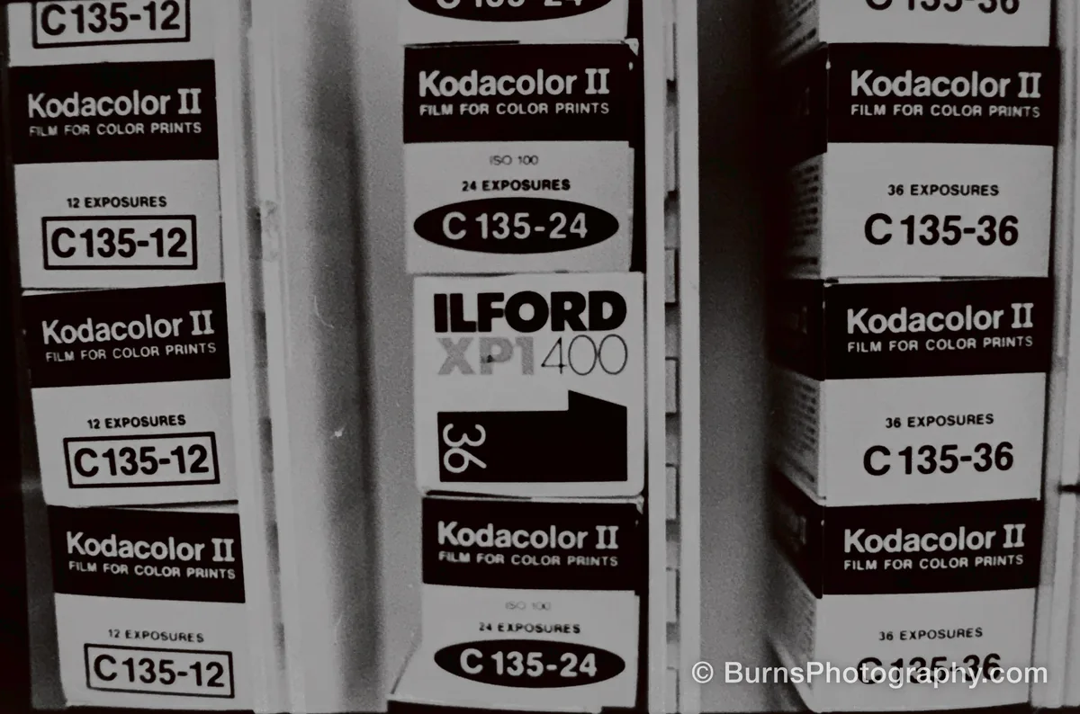 Stacked film boxes labeled Kodacolor II C135-12, C135-24, and C135-36, plus one Ilford XP1 400 box