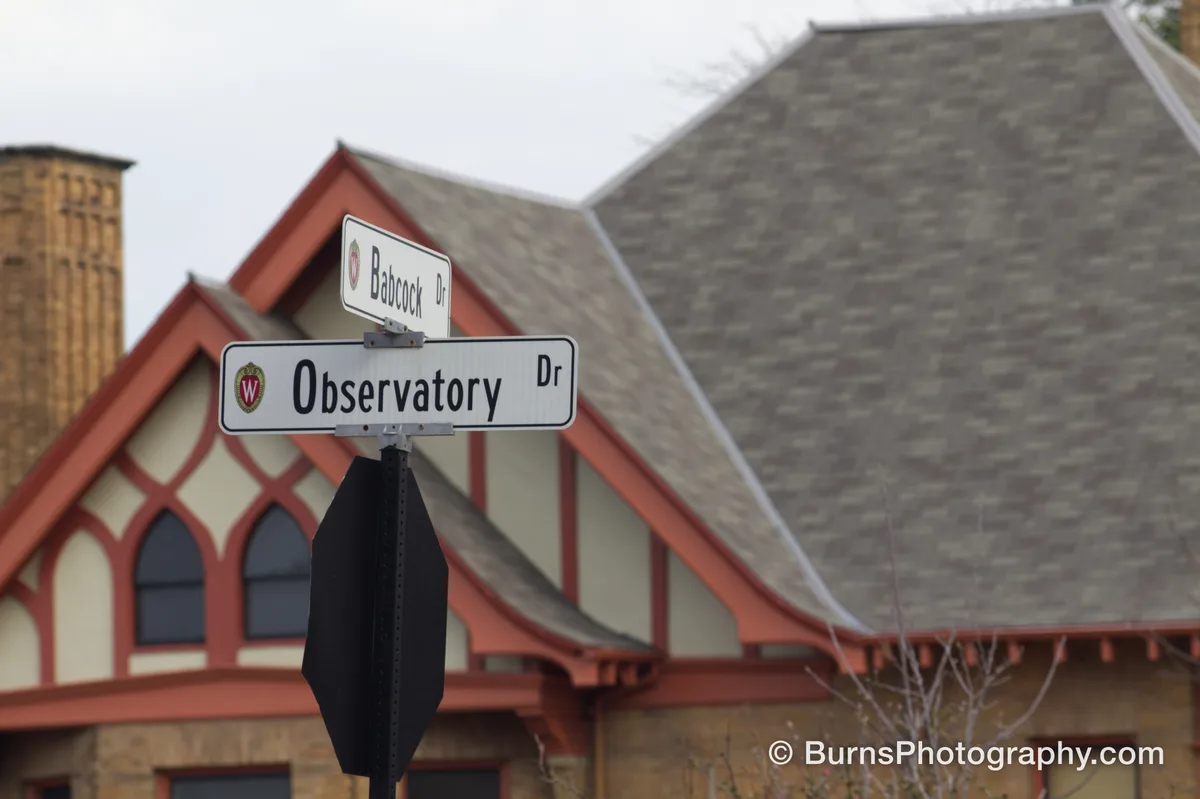 Street signs reading Observatory Dr and Babcock Dr in front of a red-trimmed gabled building