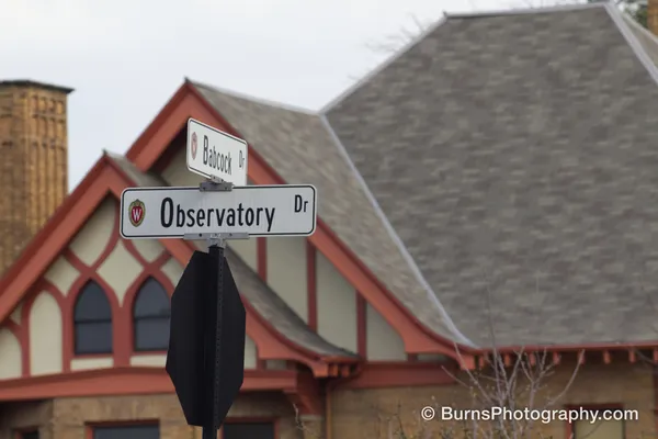 Street signs reading Observatory Dr and Babcock Dr in front of a red-trimmed gabled building